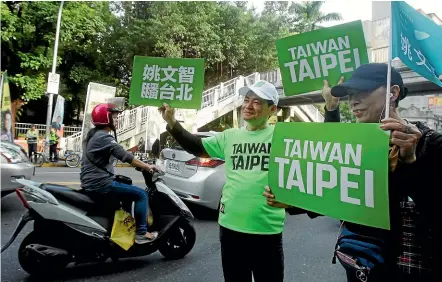  ?? AP ?? Supporters hold placards during a rally supporting a referendum on whether Taiwanese sports teams should change their names – one of many issues Taiwanese are voting on in this weekend’s local elections.