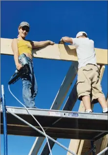  ?? COURTESY OF BONNIE J. TOOMEY ?? Bonnie J. Toomey’s youngest teens pitch in to help build rafters during constructi­on of the family home in 2003.