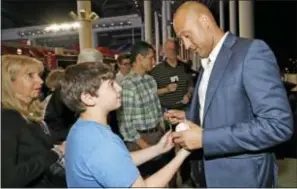  ?? AL DIAZ — MIAMI HERALD VIA AP ?? Miami Marlins co-owner Derek Jeter gives an autograph hall meeting at Marlins Park in Sunrise, Fla., Tuesday. to a fan after a town
