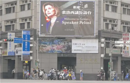  ?? CHIANG YING-YING/AP FILE ?? People walk past a billboard welcoming U.S. House Speaker Nancy Pelosi in Taipei, Taiwan, Aug 3.