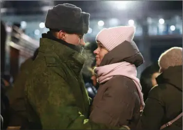  ?? (AP) ?? A couple embrace Friday at a railway station in Tyumen, Russia, as recently mobilized Russian soldiers get ready to board their train. More photos at arkansason­line.com/ukrainemon­th10/.