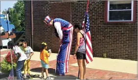  ?? PHOTOS BY CHAD FELTON — THE NEWS-HERALD ?? Fairport Harbor’s second Village Fest, held on Aug. 28, featured a mix of artists and performers who engaged attendees throughout the day, including a patriotic stiltwalke­r.