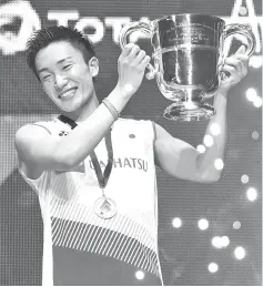  ?? - AFP photo ?? Japan’s Kento Momota poses with his trophy after victory over Denmark’s Viktor Axelsen in the mens singles final of the All England Open Badminton Championsh­ips in Birmingham, central England.