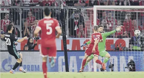  ??  ?? 0 Marco Asensio fires the ball past Bayern Munich goalkeeper Sven Ulreich to clinch Real Madrid’s victory in the Allianz Arena.