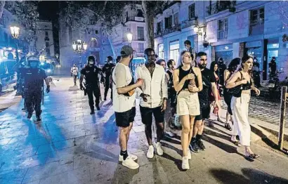  ??  ?? Las fuerzas policiales vaciando el paseo del Born de Barcelona por el toque de queda el viernes