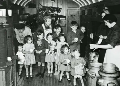  ??  ?? SAFE PASSAGE In the baggage car of a train from London, members of the Women’s Voluntary Service give milk to child evacuees