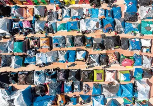  ?? GUILLERMO ARIAS/AFP ?? An aerial view Wednesday of a migrant camp where asylum seekers wait for U.S. authoritie­s to allow them to start their migration process outside El Chaparral crossing port in Tijuana, Baja California state, Mexico.