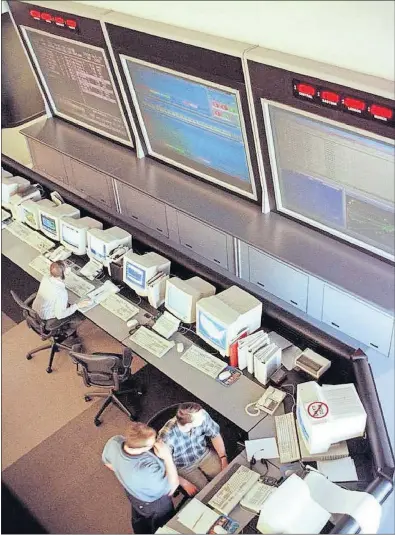  ?? [THE ASSOCIATED PRESS FILE PHOTO] ?? Technician­s watch desktop and wall-size computer monitors to check network traffic flow at CompuServe headquarte­rs in Columbus on Sept. 8, 1997.