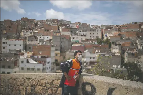  ??  ?? Noureddine Elmihnida observes his neighborho­od from a hill during a health state of emergency and home confinemen­t order in El Youssoufia, Rabat, Morocco. (AP/Mosa’ab Elshamy)