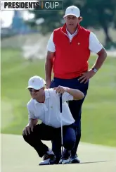  ??  ?? Phil Mickelson of the US helps team mate Zach Johnson line up a putt in their Presidents Cup foursomes match in Incheon, South Korea, on Thursday. —