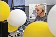  ?? BILL LACKEY / STAFF ?? Clark County dispatcher Tyler Franklin is seen through balloons that were placed around the new combined Clark County Dispatch Center to celebrate its opening Tuesday.