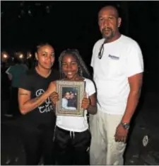  ?? LORETTA RODGERS – DIGITAL FIRST MEDIA ?? Quiana Butler, her father Steven, and daughter Ceonnah hold a photograph of Quiana’s 4-year-old daughter Ja’Miah, who was killed by a stray bullet on Oct. 28, 2004.