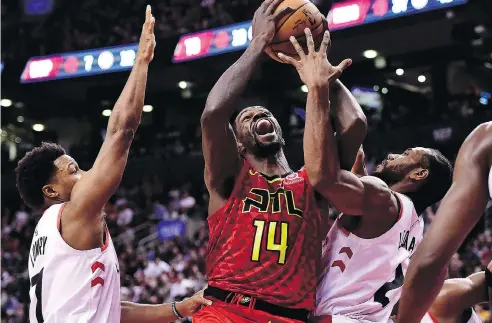  ?? FRANK GUNN / THE CANADIAN PRESS ?? Raptors guard Kyle Lowry and Kawhi Leonard defend against Atlanta Hawks centre Dewayne Dedmon on Tuesday night in Toronto.