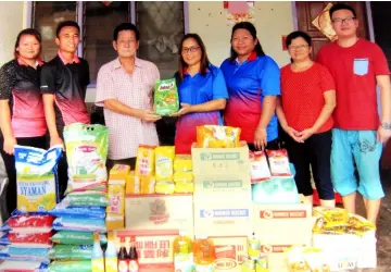  ??  ?? Lim (third left) hands over the items to PDK Sinar Harapan’s supervisor Munah Ahin.
