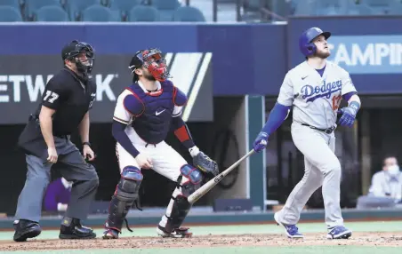  ?? Ronald Martinez / Getty Images ?? The Dodgers’ Max Muncy follows the flight of his grand slam, which capped an 11run firstinnin­g outburst against Atlanta.