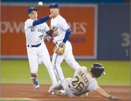  ?? The Canadian Press ?? Toronto Blue Jays shortstop Ryan Goins, left, forces out Pittsburgh Pirates left fielder Adam Frazier (26) and turns the double play during eighth-inning interleagu­e action in Toronto on Friday. The Blue Jays lost 4-2.