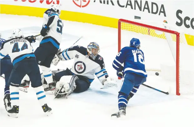  ?? NICK TURCHIARO / USA TODAY SPORTS ?? Toronto Maple Leafs winger Mitch Marner tucked a loose puck — after it had gone through Winnipeg Jets goalie Connor Hellebuyck
on a Justin Holl shot — into the vacant net in the second period to key a 3-1 victory on Monday night at Scotiabank Arena.