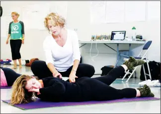  ?? LORRAINE HJALTE/CALGARY HERALD ?? Somatics instructor Martha Peterson, white shirt, works with student Evelyn McGhee, in their movement therapy craft/treatment workshop.