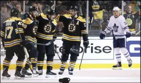 ?? AP PHOTO ?? The Boston Bruins celebrate a goal while Toronto Maple Leafs forward Auston Matthews (34) looks on during Saturday’s game.