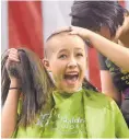  ?? GREG SORBER/JOURNAL ?? Sequoia Stapleton, 13, holds up her hair as Kaylah Thomas trims what’s left during the St. Baldrick’s Foundation event in March.