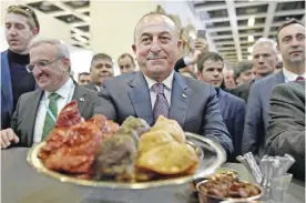  ??  ?? BERLIN: Turkish Foreign Minister Mevlut Cavusoglu (C) visits his country’s hall at the Internatio­nale Tourismus-Boerse (ITB) internatio­nal travel trade show. — AFP