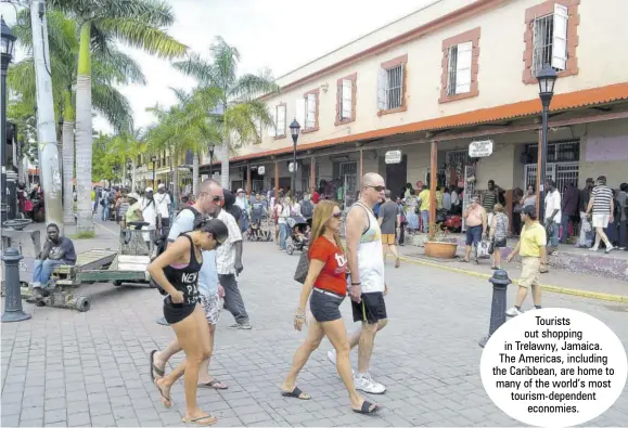  ??  ?? Tourists out shopping in Trelawny, Jamaica. The Americas, including the Caribbean, are home to many of the world’s most tourism-dependent economies.