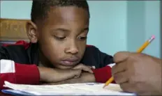  ?? ?? Christian Ensrud, 7, watches as his mother, Tamela Ensrud, helps him with his homework in Nashville, Tenn..
