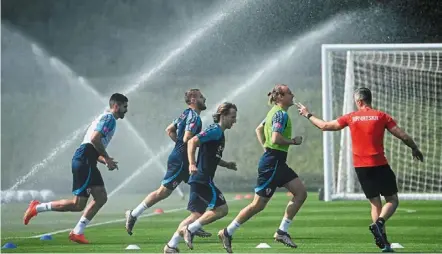  ?? — AFP ?? Nothing watered down: Croatia midfielder Luka modric (centre) and domagoj vida (second from right) join teammates in a training session at the team’s al erssal training camp in doha.