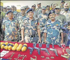  ?? PTI ?? BSF officials display arms and heroin recovered from five Pakistani infiltrato­rs near border in Tarn Taran district on Saturday.