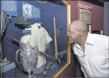  ??  ?? In this photo provided by the National Baseball Hall of Fame and Museum, Tim Raines looks at artifacts on the Museum’s second-floor timeline during his Orientatio­n Visit on Wednesday in Cooperstow­n, N.Y. Raines will be inducted on July 30.