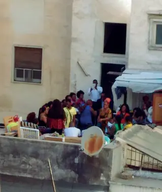  ??  ?? Un gruppo di stranieri assembrati su un balcone del quartiere Libertà