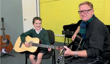  ?? MIKE BAIN ?? Once described as being very shy, seven-year-old Brodie Erskine talks to his tutor Paul Hobby about becoming a rock star and wanting to buy a house for his mum.
