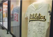  ??  ?? Major-league jerseys, including one from the A’s and another from Hall of Fame pitcher Greg Maddux, at the Mesa Historical Museum.