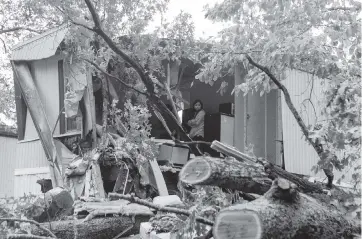  ?? CHRISTINA MATACOTTA Atlanta Journal-Constituti­on ?? Alicia Martinez stands in her grandmothe­r’s trailer where a man was killed by a fallen tree early Thursday in Acworth, Georgia. Strong gusts from Hurricane Zeta caused the tree to fall, bringing down power lines and trees in north Georgia.