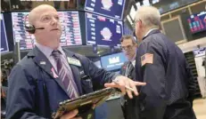  ?? — Reuters ?? Traders work on the floor of the New York Stock Exchange.