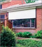  ??  ?? Columnist James Dulley installed a Roll-A-Way exterior rolling shutter over a large picture window in his family room. When the rolling shutter is completely open, right, the small housing under the sof t is barely noticeable.