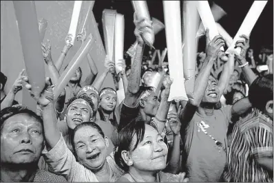  ?? AP/ KHIN MAUNG WIN ?? Supporters of Aung San Suu Kyi cheer as they watch results Monday from Sunday’s historic elections that will test whether a popular mandate can loosen the military’s longstandi­ng grip on power.