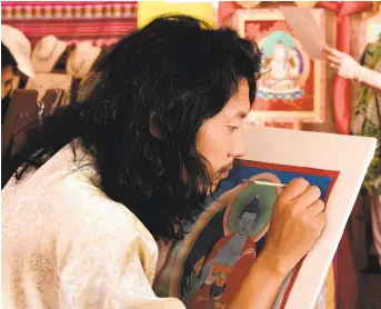  ?? NEW MEXICAN FILE PHOTO ?? Kalsang Tashi of Tibet paints as the early bird crowd arrives to the 2016 Folk Art Market on Museum Hill. This year, 162 artists have been invited to participat­e in the market.