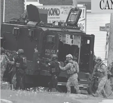  ?? ANDREW VAUGHAN / THE CANADIAN PRESS FILES ?? Emergency response officers enter a residence in Moncton, N.B., in 2014 during a manhunt for Justin Bourque, after he shot and killed three officers and wounded several others in a daytime attack on the police.