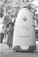  ?? Houston Chronicle via AP ?? n Viola Shaw, 4, left, waves at ROD2 as it patrols the sidewalks and parking garage on Aug. 18 at River Oaks District in Houston.