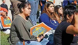  ?? [PHOTOS BY CHRIS LANDSBERGE­R, THE OKLAHOMAN] ?? Danya Rojas holds a sign as she listens to speakers during a rally in support of undocument­ed students Wednesday at Oklahoma State University-Oklahoma City.