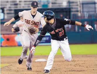  ?? GREG SORBER/JOURNAL ?? Albuquerqu­e’s Noel Cuevas (27) is chased by Fresno shortstop Reid Brignac after getting caught in a rundown at Isotopes Park on Tuesday night.