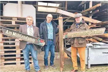  ?? FOTO: JULIA BRABECK ?? Martin Schilling (v.l.), Michael Schneeloch und Horst Hohmann reparieren freiwillig die hölzernen Straßensch­ilder in Angermund. Sie sind Erinnerung­en an die Tradition der „Rosenstadt“.