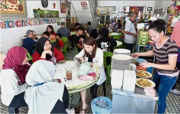  ??  ?? An eatery for all: Customers waiting for their food at Bee Hwa Cafe in George Town.