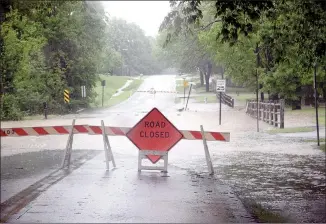  ?? LYNN KUTTER ENTERPRISE-LEADER ?? Farmington Street Department closed Hunter Street at Creekside Park on Saturday. The creek was running outside its bed and across the road. This was about 2:20 p.m. Saturday, before another hard rain hit later in the day.