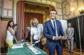  ?? CHRISTOPHE PETIT-TESSON /POOL PHOTO VIA ASSOCIATED PRESS ?? French President Emmanuel Macron and his wife, Brigitte, pick up ballots before voting in the first round of the two-stage legislativ­e elections in Le Touquet, northern France, on Sunday.