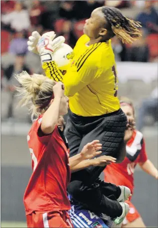  ?? IAN LINDSAY/ PNG ?? Canada’s Kelly Parker ( left) goes to the net as keeper Ednie Limage of Haiti makes the save that left her injured Thursday. Limage is in hospital but tests have reveal no serious injuries.