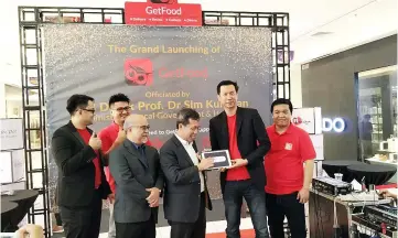  ??  ?? Dr Sim (third right) presses a button on a tablet to officially launch the GetFood app. Also seen are Koh (second right), iCube Innovation chairman Dato Patrick Liew (third left) and others.
