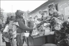  ?? LI JIEYI / XINHUA ?? Right: Breakfast is distribute­d on Monday to flood-hit villagers in Mianning county, Sichuan province. The Communist Party of China has always made serving the people its priority.