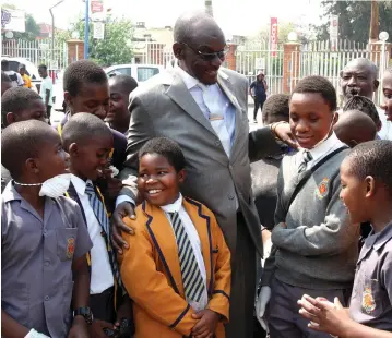  ?? — Picture: Kudakwashe Hunda ?? Vice President Kembo Mohadi interacts with pupils from Louis Mountbatte­n Primary School after leading a clean-up exercise at Fife Avenue Shopping Centre in Harare yesterday.
